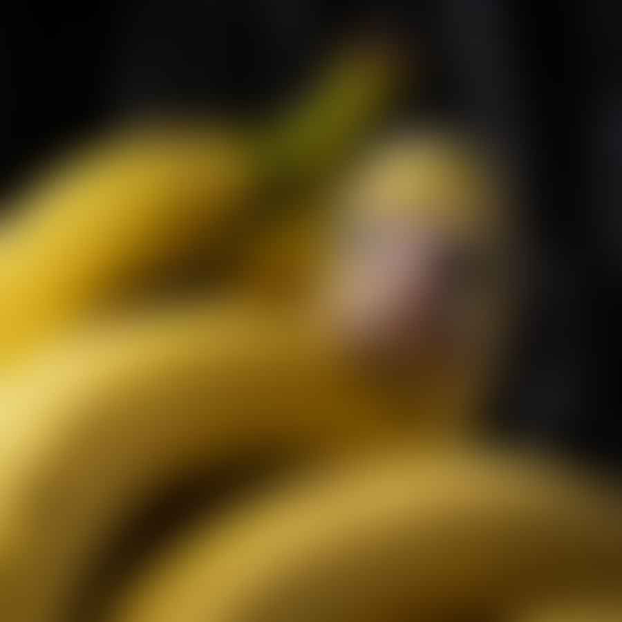 A chicken peaking at a banana